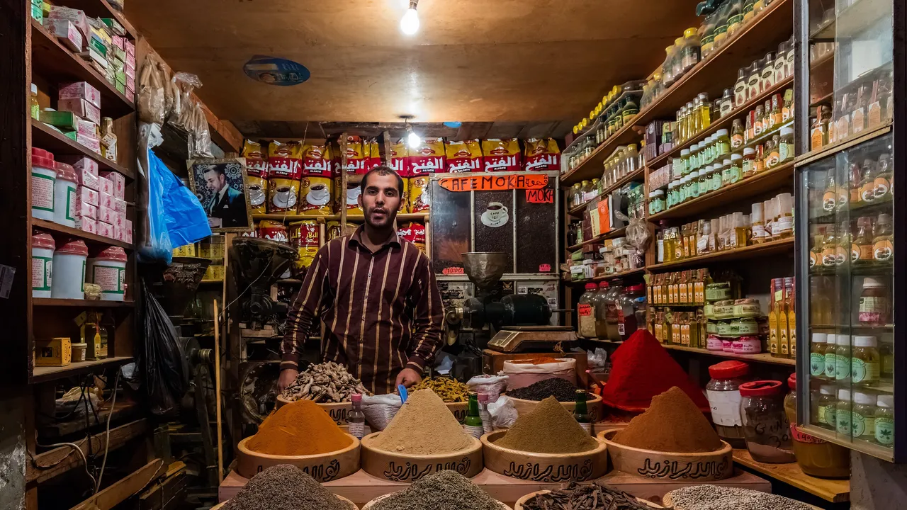 Épicier dans sa boutique remplie de produits et d'épices, place du Grand Socco à Tanger